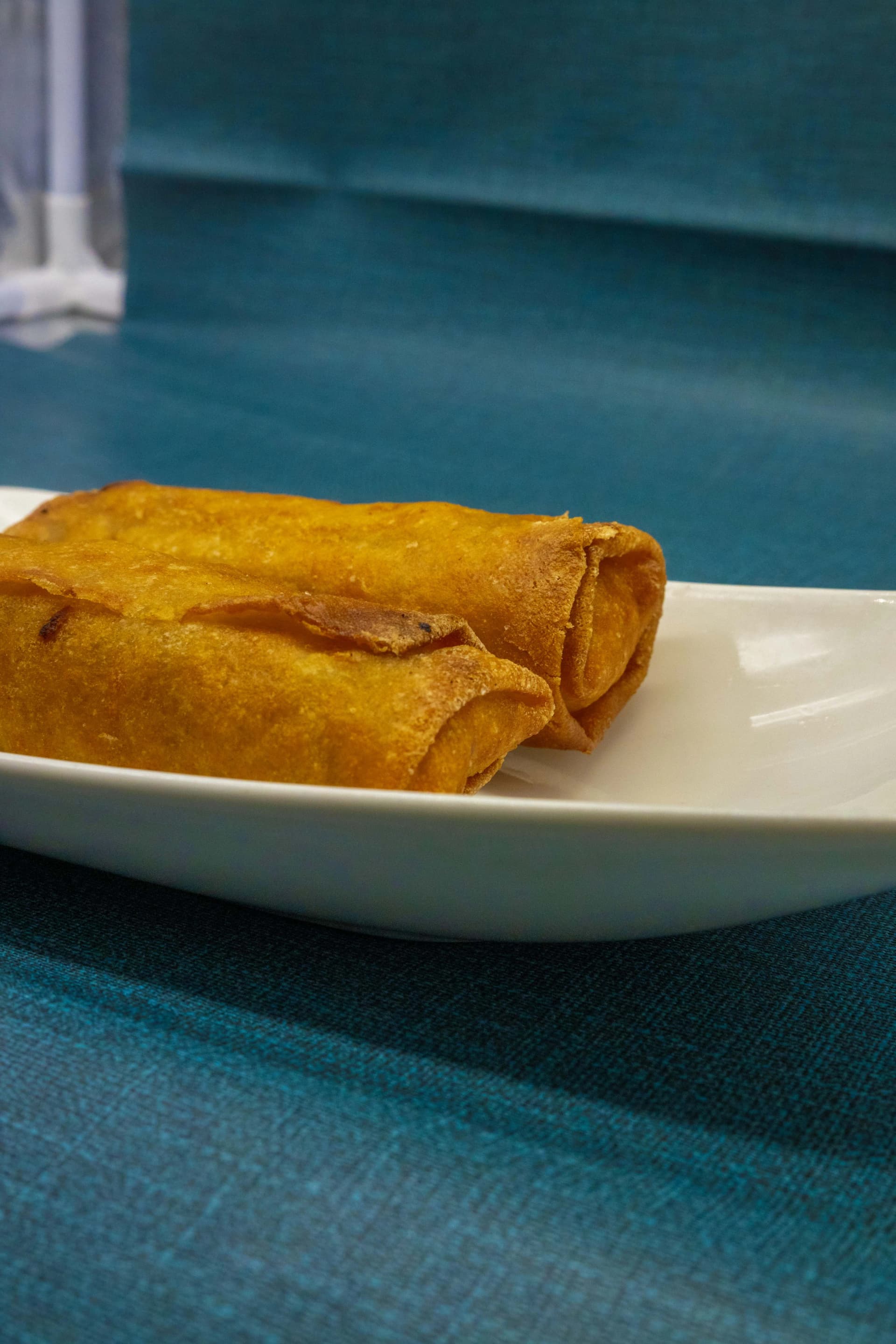 Rollitos de primavera fritos y dorados servidos en plato blanco sencillo
